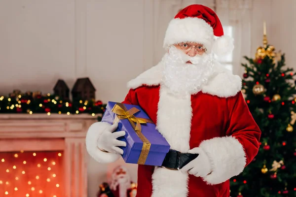 Santa holding gift box — Stock Photo