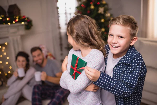 Geschwister mit Weihnachtsgeschenk — Stockfoto