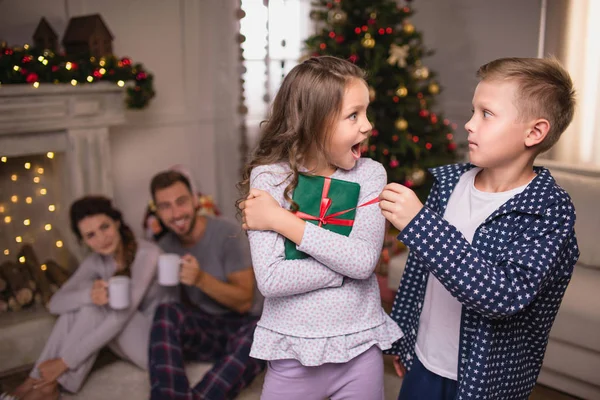 Siblings with christmas gift — Stock Photo