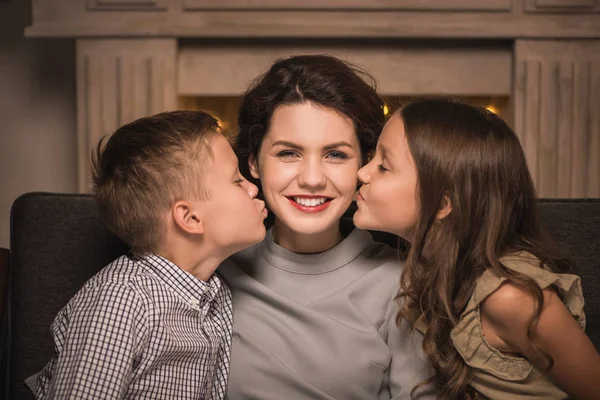 Enfants embrasser mère souriante — Photo de stock