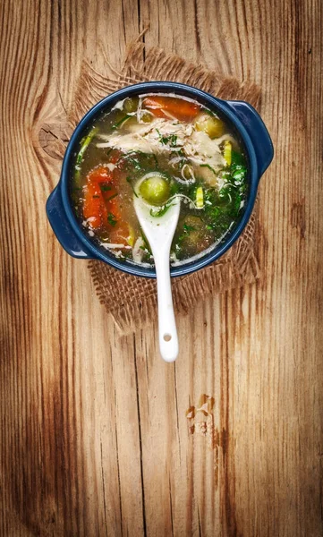 Chicken soup with vegetables on wooden table — Stock Photo, Image