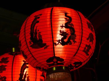 Closeup of red Chinese paper lantern with bird and dragon clipart
