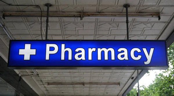 Неопределенный универсальный неоновый знак аптеки над входом в аптеку — стоковое фото