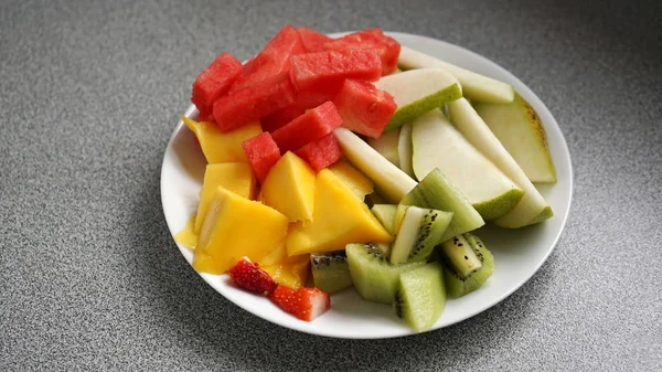 Primer plano de ensalada de frutas en rodajas sobre fondo gris — Foto de Stock