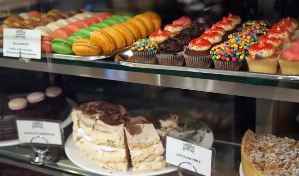 Tészta shop ablak bemutatás-val sokféle a cupcakes, muffin, sütemények és macaroons — Stock Fotó