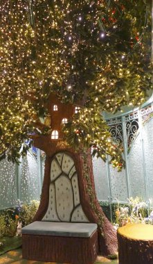 Noel Baba'nın tebrik Whimsical Bahçe, çiçek kaplı ve sönen ışıkları ile donatılan evinde. Kraliçe Victoria Bina içinde gizemli Bahçe Pavyonu.