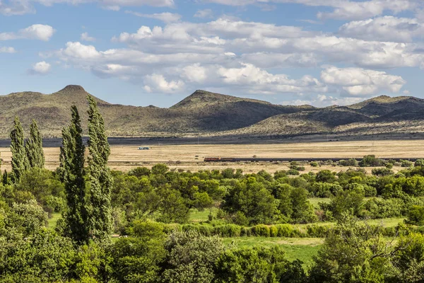 Cena de paisagem com trem passando à distância — Fotografia de Stock