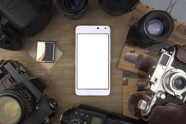 View from the top on smartphone of photographer, photos, cameras and photo accessories laying on the table. — Stock Photo, Image