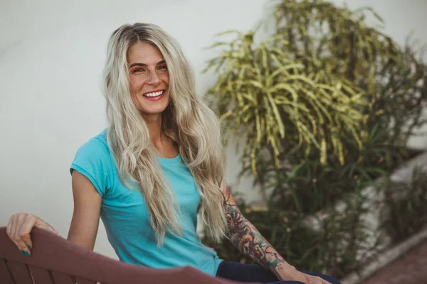 Closeup portrait of cheerful blonde woman in a turquoise t-shirt smiles a perfect smile. Modern woman. Turquoise color — Stock Photo, Image