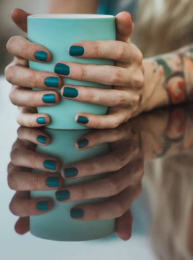 Eller turkuaz kupa dayanabiliyor kapatın. Masanın üzerinde yansıması. açık havada yemek, modern kız içecekler kahve.