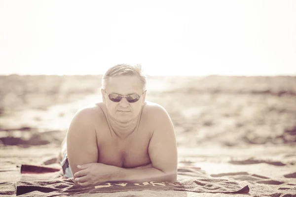 L'uomo che riposa su una spiaggia — Foto Stock