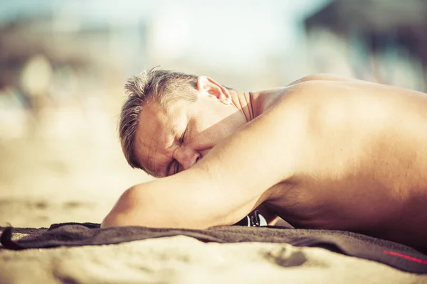 Hombre descansando en una playa — Foto de Stock