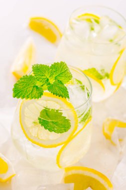 Bir bardakta limonata: su, buz, limon dilimi ve nane