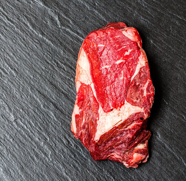 Top view on stone surface with raw steak close up