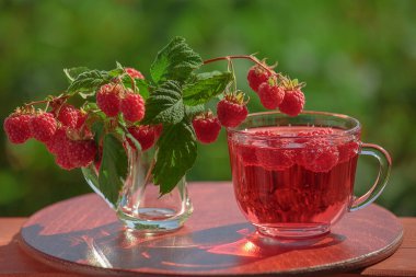 Ahududu içki ve bir buket dallar ahududu meyveleri ile birlikte.