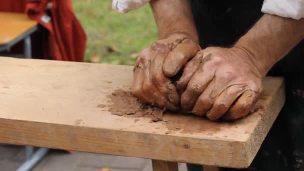 Primo piano con le mani di un vasaio. Un pezzo di argilla nelle mani degli uomini . — Video Stock