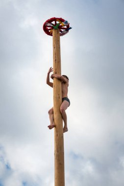 Bir adam bir sütun tırmanıyor. Karnaval Festivali