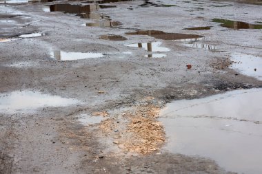 Yoldaki çukurlar ve su birikintileri.