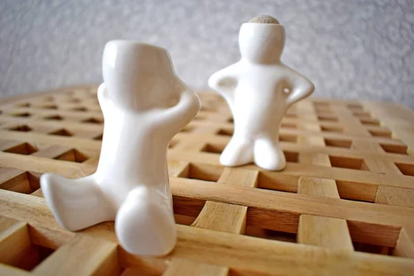 Figure di marmo di una persona allegra su una superficie di legno — Foto Stock