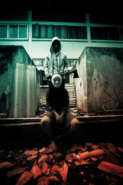 Hombre misterioso llevando un hacha y una mujer con máscara blanca, fondo aterrador para Halloween e ideas de portada de libro — Foto de Stock