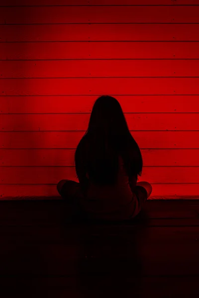 Chica sentada y mirando a la pared, Fondo de miedo para el concepto de Halloween y libro de ideas de portada — Foto de Stock