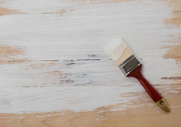 Used paint brush on wooden floor background — Stock Photo, Image