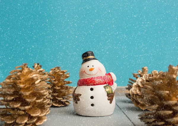 Adorno de Navidad con muñeco de nieve y cono de pino en la nieve — Foto de Stock