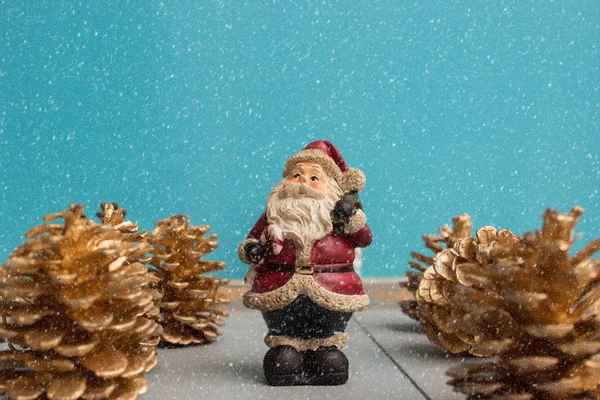 Ornament de Crăciun cu Moș Crăciun pe fundal din lemn cu con de pin și zăpadă — Fotografie, imagine de stoc