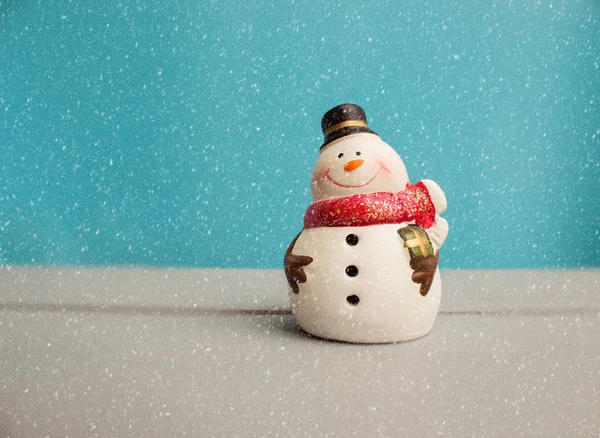 Adorno de Navidad con muñeco de nieve sobre fondo de madera con nieve — Foto de Stock