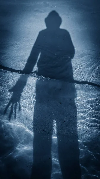 Fuera del agua, la sombra de la persona se refleja en la arena y el agua, * * disparado con un teléfono inteligente —  Fotos de Stock