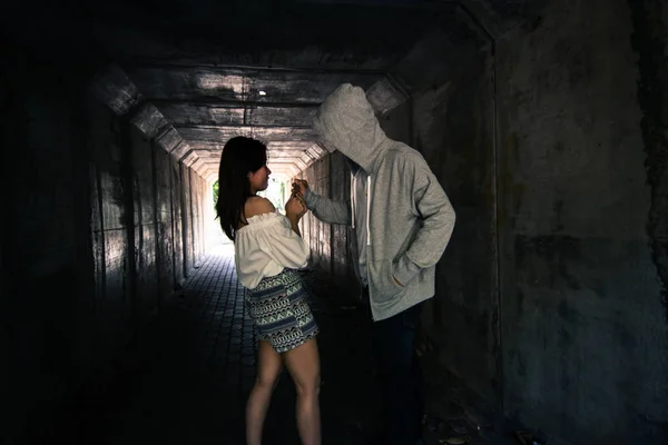 Social Issues, Beautiful woman walking in the tunnel and being attack by stalker — стоковое фото