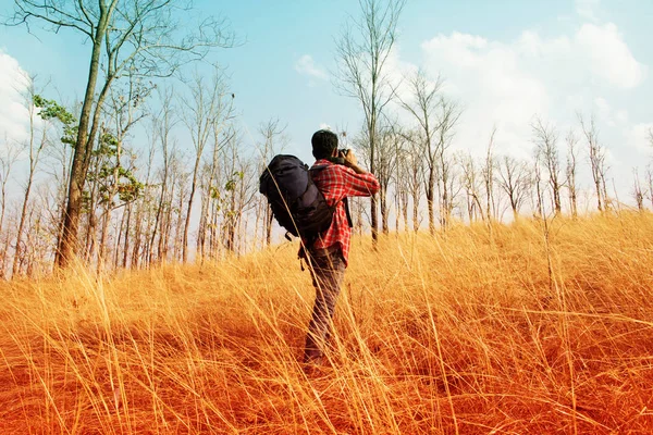 Viajante com mochila tirando foto na montanha — Fotografia de Stock