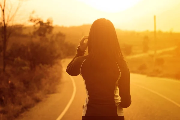 Vrouw in sportkleding wandelen buiten tijdens het luisteren muziek — Stockfoto