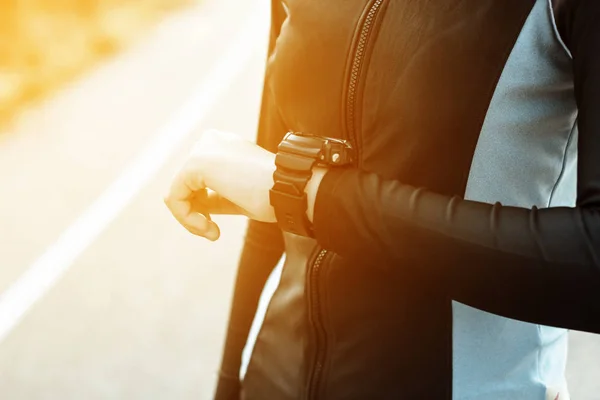 Woman in sportswear looking at watch — Stock Photo, Image