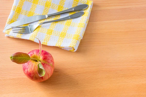 Rött äpple och servett med bestick på trä bakgrund. Kost — Stockfoto