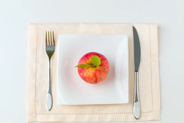 Roter Apfel auf einem Teller. Ernährungskonzept. — Stockfoto