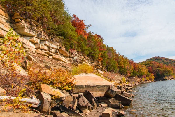 Podzimní sezóna u jezera s krásnými lesy na pobřeží skalnaté kopce. — Stock fotografie
