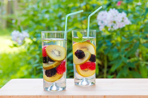 Infused water with  berries and golden kiwi. — Stock Photo, Image