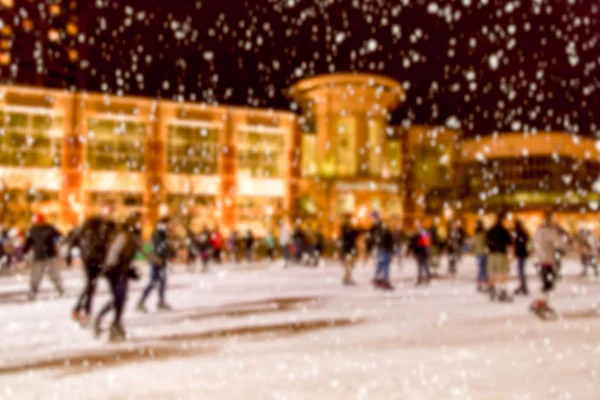 Defocused outdoor ice skating rink with skating people in winter — Stock Photo, Image