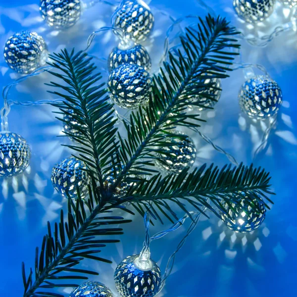 Fondo de Navidad abstracto con luces de guirnalda y rama de pino — Foto de Stock