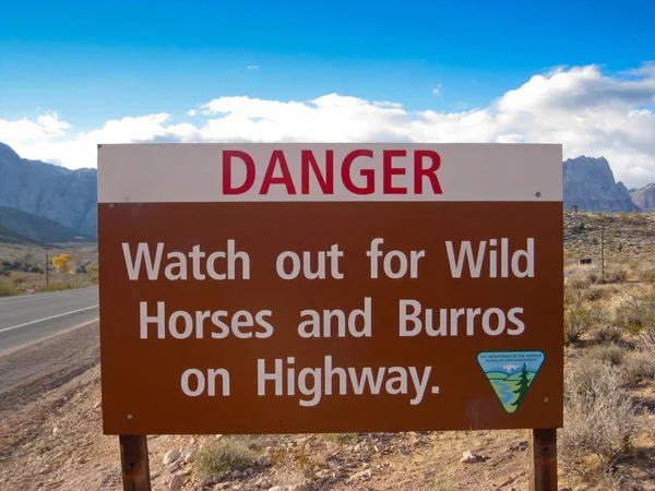 Señal de advertencia de caballos salvajes y burros en la carretera . —  Fotos de Stock