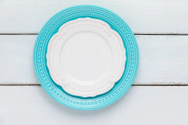 Белые и синие тарелки на деревянном столе . — стоковое фото