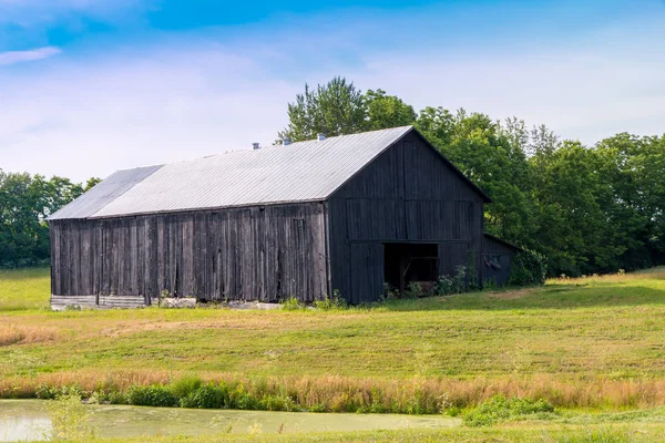 Old barn near pond. — Stock Photo, Image