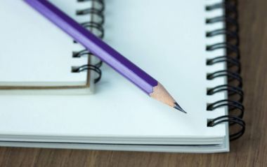 Ahşap masa, seçici foc üstünde kalem ve spiral defter kapatmak