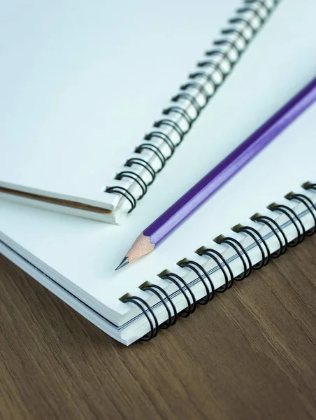 Närbild penna och spiral notebook på bord av trä, selektiv foc — Stockfoto