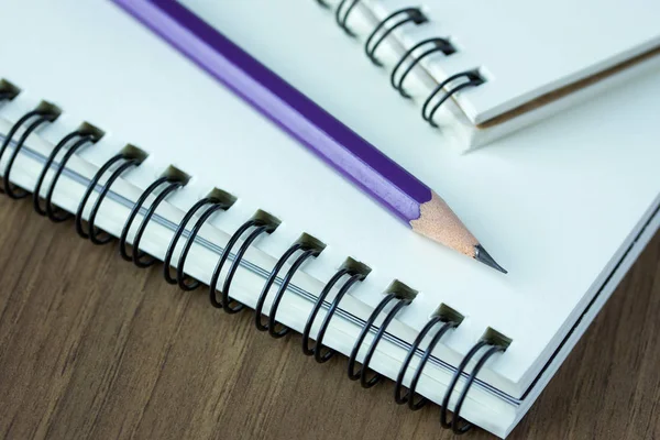 Fechar lápis e caderno em espiral sobre mesa de madeira, Seletivo foc — Fotografia de Stock