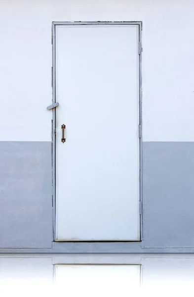 Белая деревянная дверь на белой и серой стене — стоковое фото