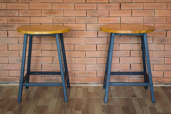 Два дерев'яні стільці на фоні цегляної стіни — стокове фото
