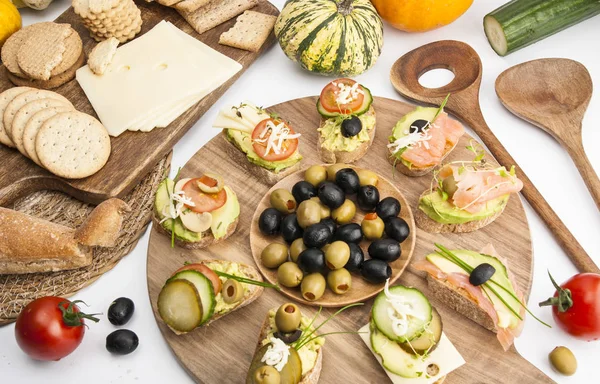 Sandwiches, cheese, crackers and vegetables on wooden boards on — Stock Photo, Image