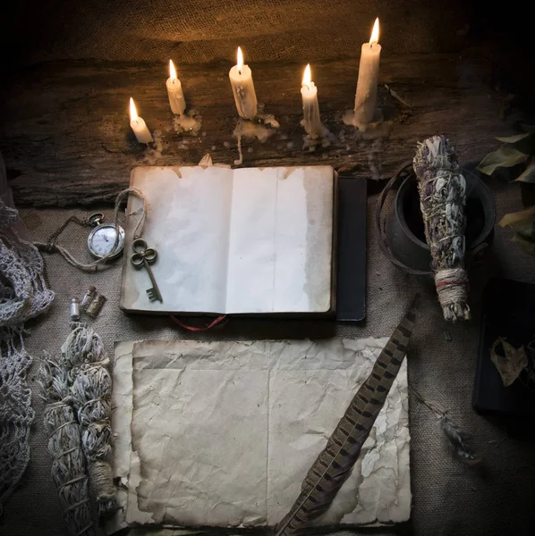 Υπόβαθρο με ένα παλιό βιβλίο και το χαρτί πάνω στο τραπέζι με κεριά — Φωτογραφία Αρχείου